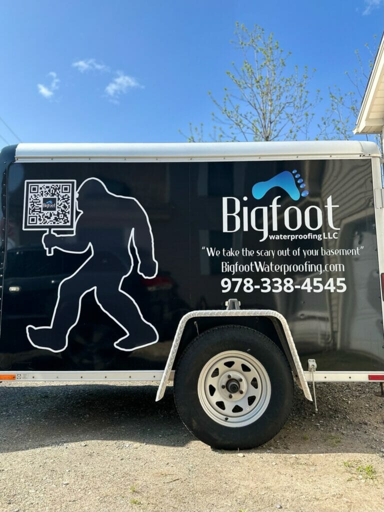 Bigfoot company trailer with company phone number and QR code on side