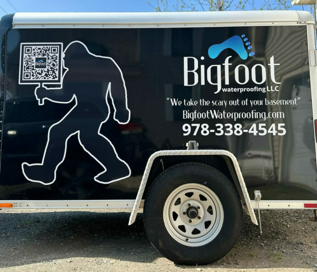 Bigfoot company trailer with company phone number and QR code on side